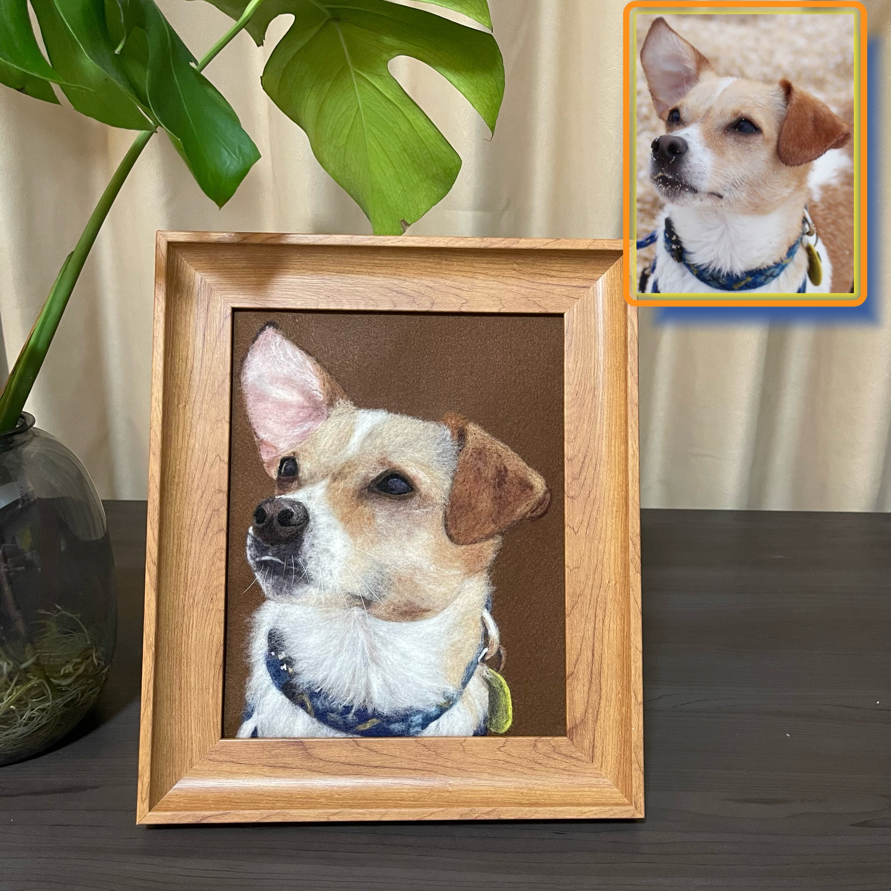 Framed portrait of a dog on a table with a plant in the background